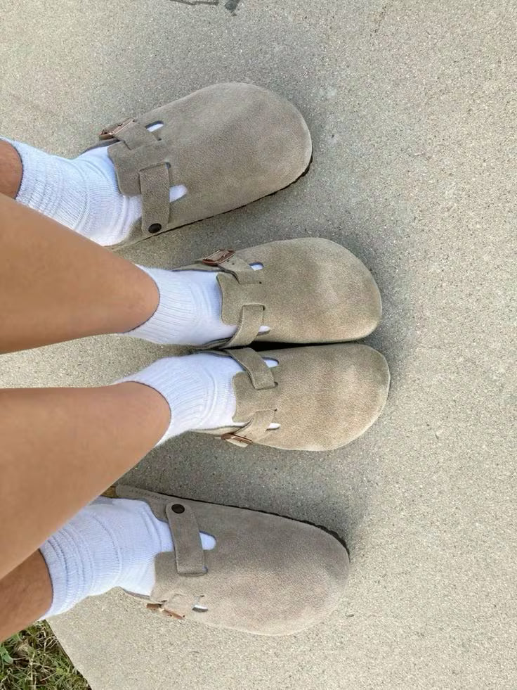 Beige shoes worn with white socks on a concrete surface
