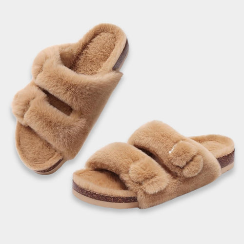 Pair of brown fuzzy slippers on a light gray background