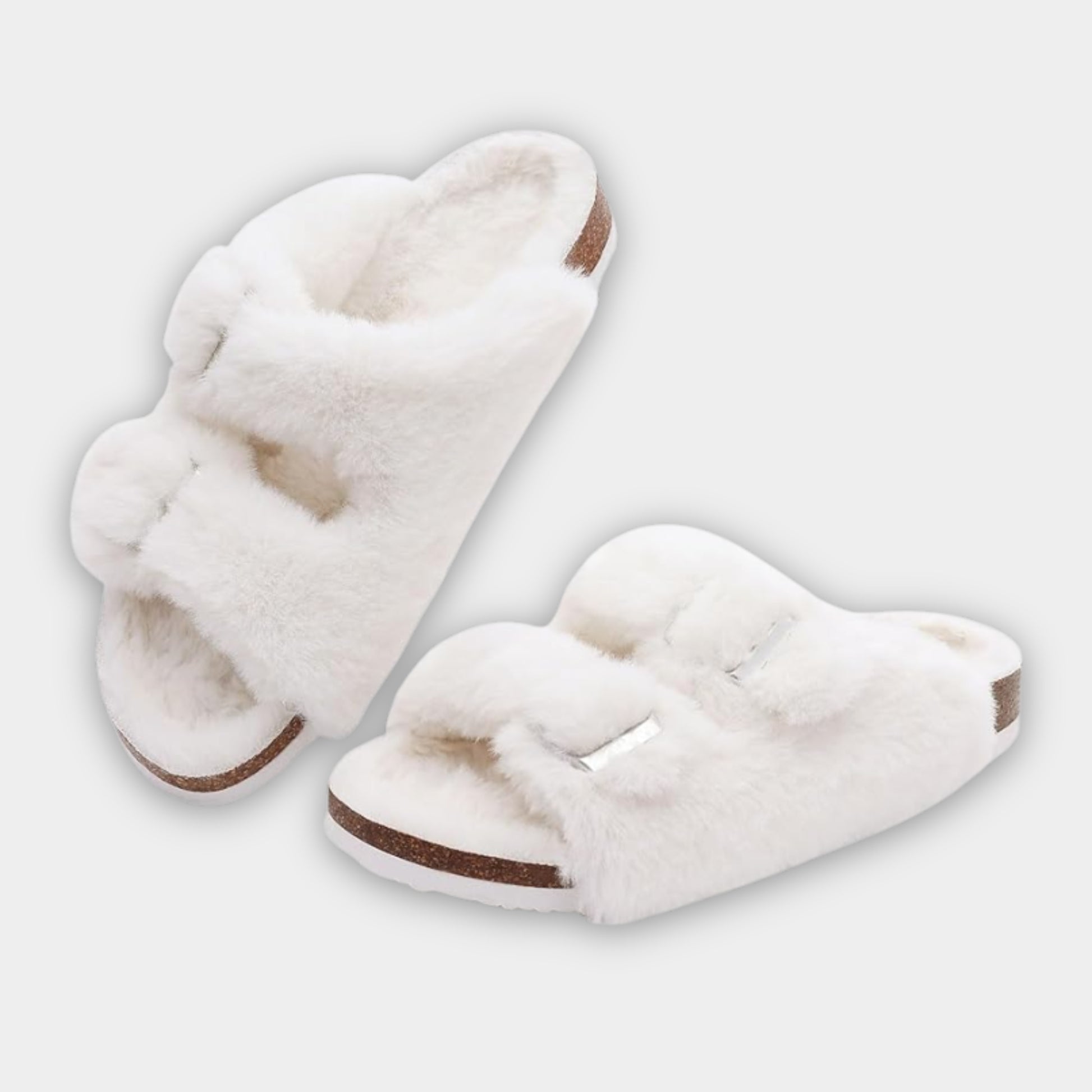 Pair of white slippers with brown soles on a light gray background