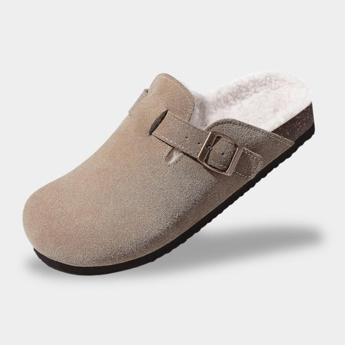 Brown suede clog shoe with a buckle on a light gray background