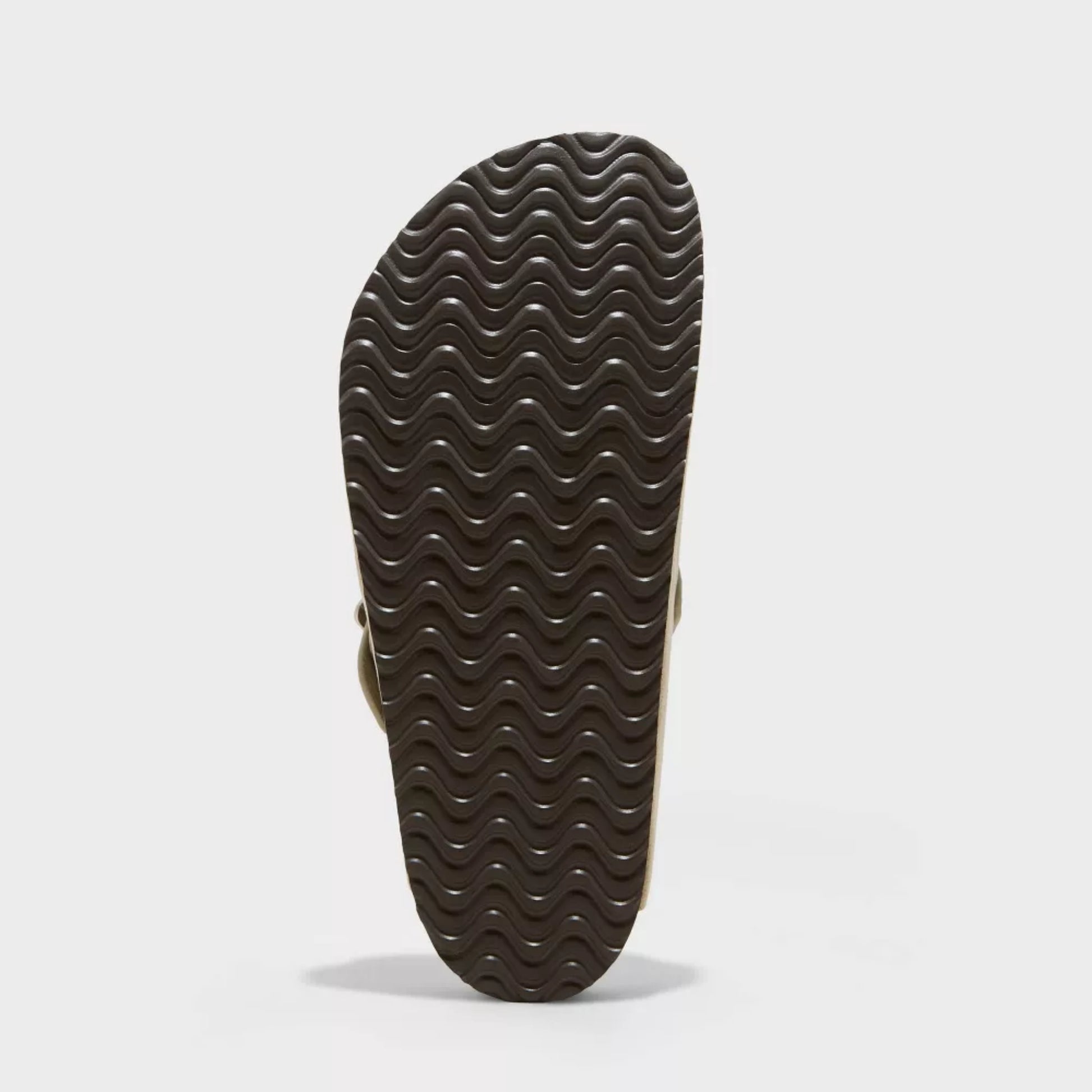 Close-up of a sandal sole with wavy pattern on a light gray background
