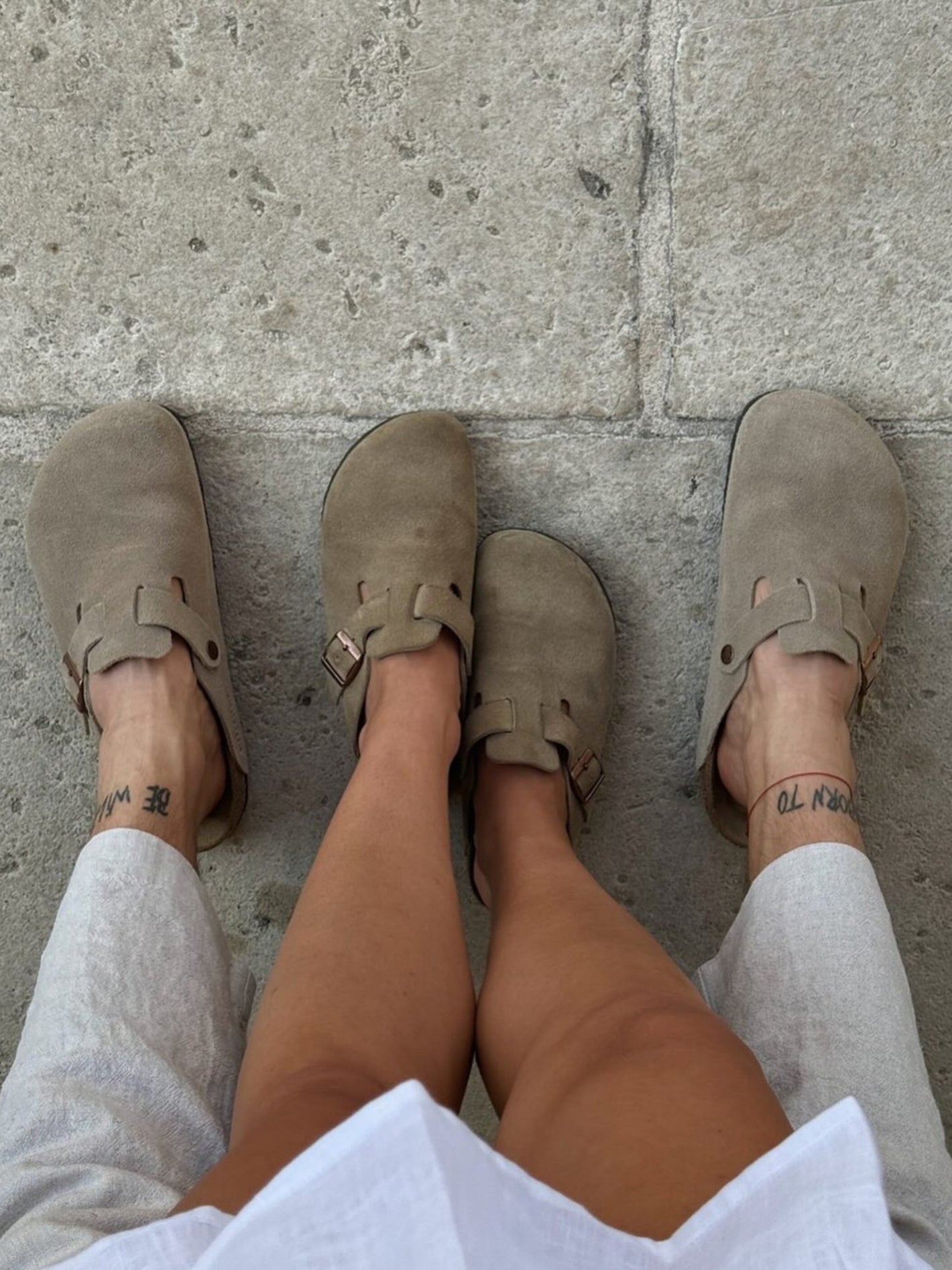 Beige clogs worn on a stone pavement