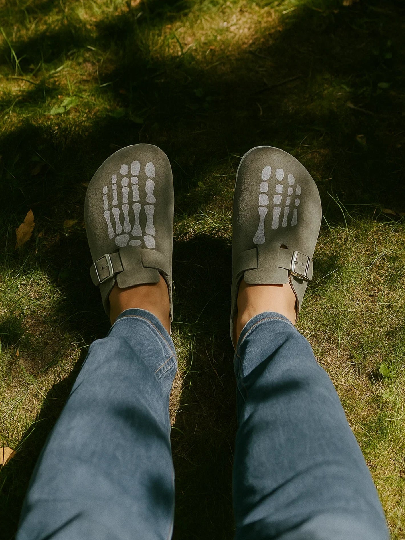 Person wearing gray sandals with unique sole design on grass